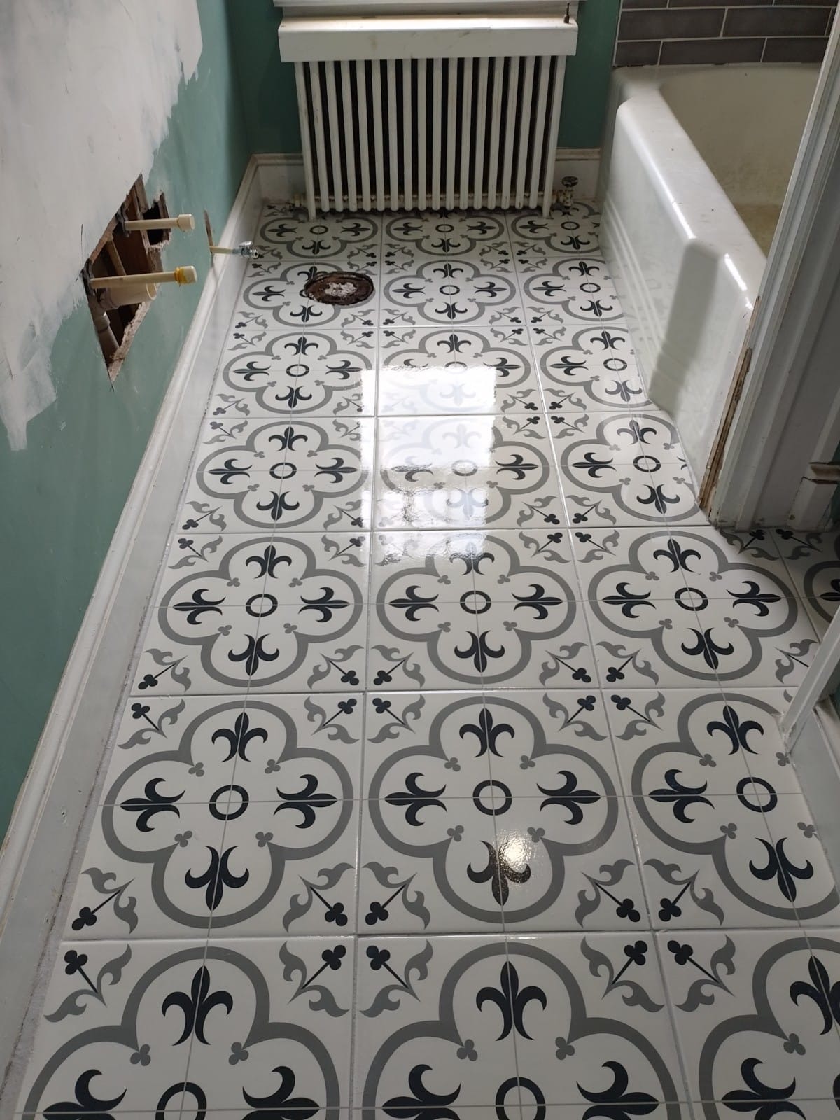 New patterned ceramic tile floor installed during a bathroom remodel